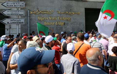 Demonstrators carry flags as they walk past Algiers Stock Exchange during an anti-government protest in Algiers, Algeria, August 23, 2019. PHOTO BY REUTERS/Ramzi Boudina