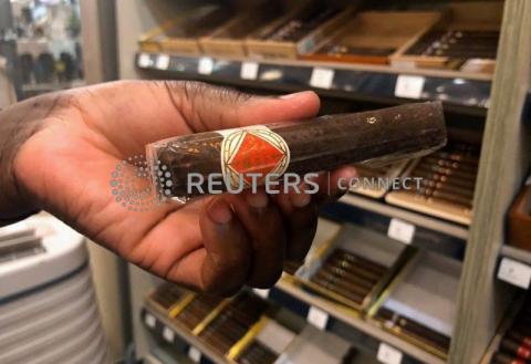 A sales assistant holds a Bongani cigar, produced in Mozambique, in a tobacconist's store in Johannesburg, South Africa, January 17, 2020. PHOTO BY REUTERS/Emma Rumney