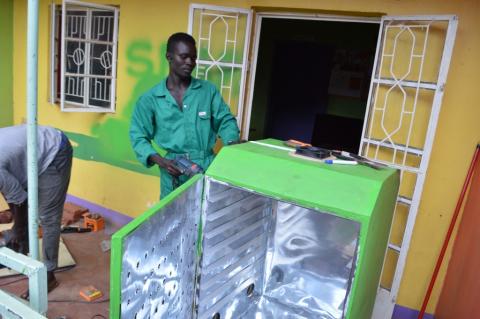 Lawrence Okettayot and Morris Opiyo work on a 'sparky' food dryer at their workshop in Kampala, Uganda, May 13, 2019. PHOTO BY Thomson Reuters Foundation/John Okot