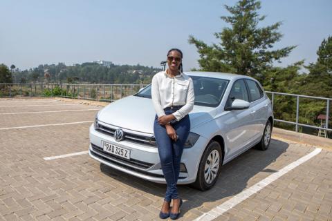 Rwandan Joseline Iradukunda poses next to her "Move" app-driven ride-hailing service Volkswagen Polo in Kigali, Rwanda, September 23, 2019. PHOTO BY REUTERS/Jean Bizimana