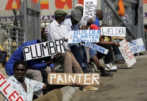 Men hold placards offering temporal employment services in Glenvista, south of Johannesburg, October 7, 2010. PHOTO BY REUTERS/Siphiwe Sibeko