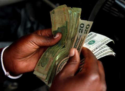 An illegal money changer counts dollar notes in Harare, Zimbabwe, January 10, 2019. PHOTO BY REUTERS/Philimon Bulawayo