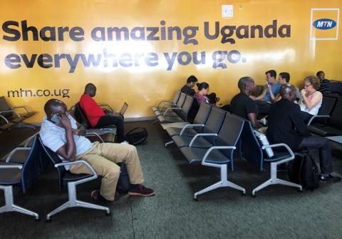 Passengers use their mobile phones at the departure lounge of the Entebbe international airport in Entebbe, Uganda, January 26, 2019. PHOTO BY REUTERS/Thomas Mukoya