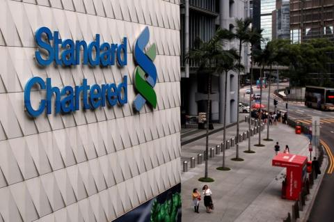 People walk outside the main branch of Standard Chartered in Hong Kong, China, August 1, 2017. PHOTO BY REUTERS/Bobby Yip