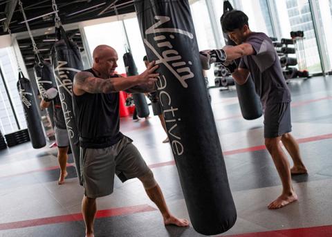 A trainer guides a gym member punching a sandbag at Virgin Active fitness club in central Singapore, March 5, 2019. PHOTO BY REUTERS/Loriene Perera