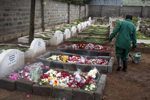 A cemetery worker walks near the fresh graves (L) of Selima Merali, 41, and her daughter Nuriana Merali, 15, who were killed in the attack by gunmen at the Westgate Shopping Centre