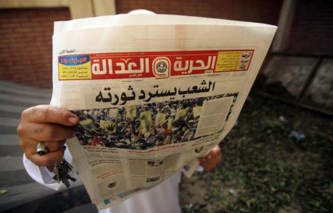 A man reads the Muslim Brotherhood's newspaper Al-Hurriya wa-l-adala