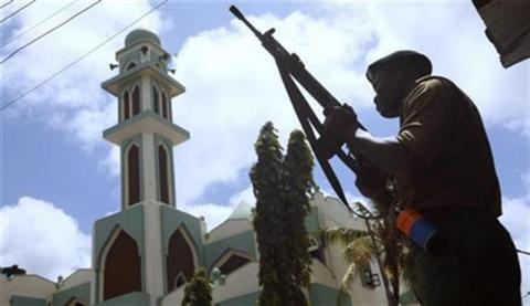 A police officer holds his position outside the Masjid Mussa mosque during an operation to suppress demonstrators reacting to the killing of an Islamic cleric