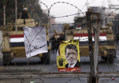 A poster of ousted Egyptian President Mohamed Mursi is pictured on barbed wires during a protest by his supporters