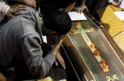 A relative mourns during the funeral for four victims killed in an attack at a wedding on Sunday