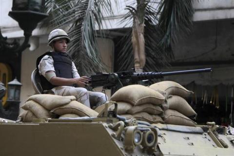 A soldier sets on an armoured personnel carrier (APC) near the Egypt stock exchange near Tahrir Square in Cairo