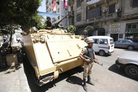 A soldier stands next to an armoured personnel carrier (APC) near the al-Fath mosque on Ramses Square in Cairo