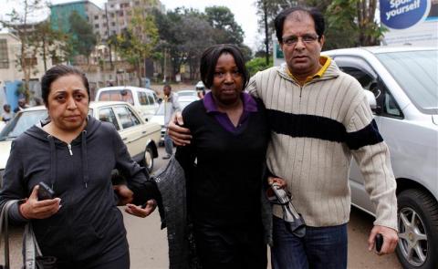 A woman (C) is escorted after being evacuated from the Westgate shopping mall in Nairobi