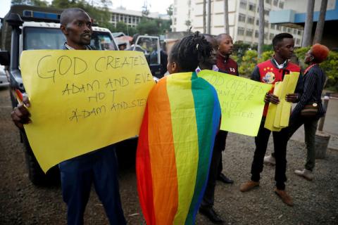 An LGBT activist walks past anti-gay rights protesters holding placards, after a ruling by Kenya's high court to upheld a law banning gay sex, outside the Milimani high Court in Nairobi, Kenya, May 24, 2019. PHOTO BY REUTERS/Baz Ratner