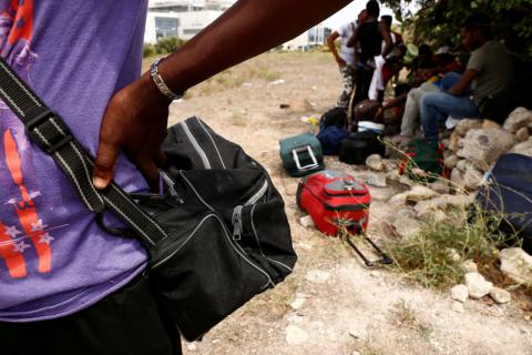 Evicted migrants wait in a field near a farm where police evicted some 110 African migrants who had been living in stalls formerly used by cows, in Qormi, Malta, August 13, 2018. PHOTO BY REUTERS/Darrin Zammit Lupi