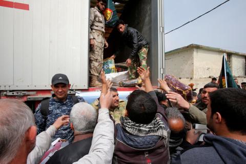 Civilians queue for humanitarian aid packages in Al Ghizlane district as the battle against Islamic State's fighters continues in Mosul, Iraq, March 20, 2017. PHOTO BY REUTERS/Youssef Boudlal