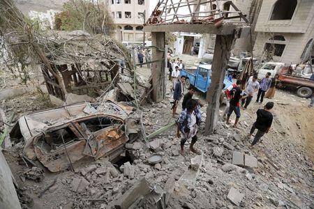 People stand at the site of a Saudi-led air strike in Yemen's capital Sanaa, August 30, 2015. PHOTO BY REUTERS/Khaled Abdullah