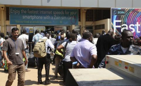 Locals and foreign nationals gather at Juba International Airport as they wait for flights out of the South Sudanese capital Juba