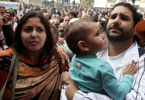 Alaa Abdel Fattah (R), one of the activists who was summoned by the public prosecutor on whether he had a role in the recent violent anti-Islamists protests, arrives with his wife and child to the public prosecutor's office in Cairo