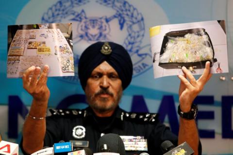 Amar Singh, head of Malaysia's Commercial Crime Investigation Department (CCID), displays photos of items from a raid during a news conference in Kuala Lumpur, Malaysia, June 27, 2018. PHOTO BY REUTERS/Lai Seng Sin