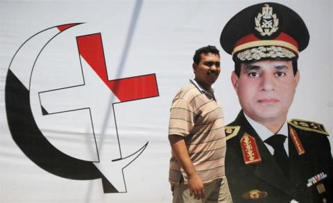 An anti-Mursi supporter of Egypt's army walks in front of his shop