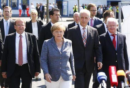 Heidenau major Juergen Opitz, German Chancellor Angela Merkel, Saxony State Prime Minister Stanislaw Tillich and President of the German Red Cross Rudolf Seiters (LtoR) arrive for statements after their visit to an asylum seekers accomodation facility in the eastern German town of Heidenau near Dresden, August 26, 2015. PHOTO BY REUTERS/Axel Schmidt