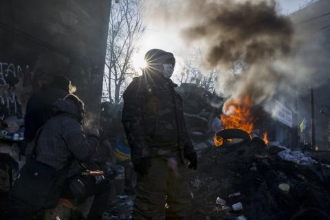 Anti-government protesters gather at an open fire site as temperatures stand at minus 20 degrees Celsius (minus 4 degrees Fahrenheit) at a barricade near Independence Square in Kiev