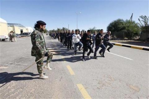 A Libyan army soldier watches as recruits train in Tripoli