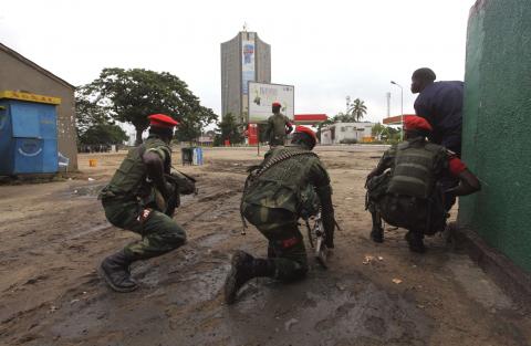 Congolese security officers position themselves as they secure the street near the state television headquarters (C) in the capital Kinshasa