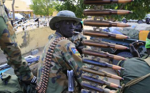 A South Sudan army soldier stands next to a machine gun mounted on a truck in Malakal town, 497km (308 miles) northeast of capital Juba, December 30, 2013 a few days after retaking the town from rebel fighters