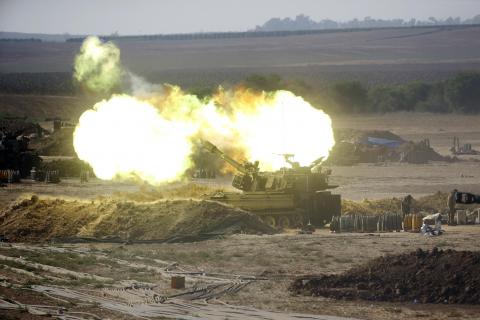 An Israeli mobile artillery unit fires towards the Gaza Strip