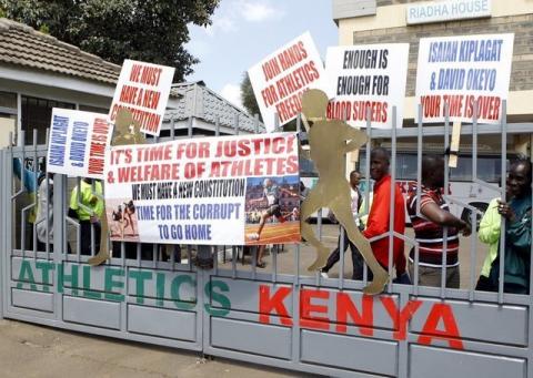 Protesting Kenyan athletes place placards behind closed gates at Riadha House the Athletic Kenya (AK) Headquarters in capital Nairobi, November 23, 2015. PHOTO BY REUTERS/Noor Khamis