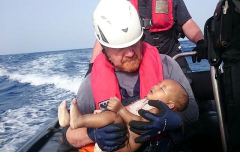 A German rescuer from the humanitarian organisation Sea-Watch holds a drowned migrant baby, off the Libyan cost, May 27, 2016. PHOTO BY REUTERS/Christian Buettner