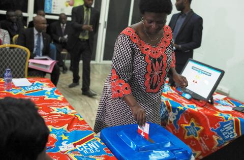 A woman casts a mock ballot after using an electronic voting machine during a demonstration inside Congo's electoral commission (CENI) head offices in Gombe Municipality of Kinshasa, Democratic Republic of Congo, March 1, 2018. PHOTO BY REUTERS/Robert Carrubba