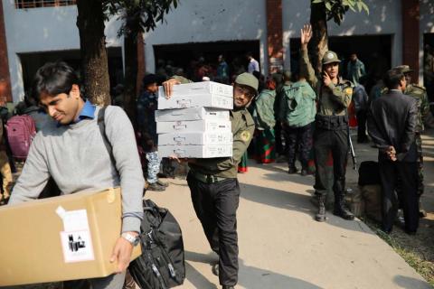 Law enforcement officials carry electronic voting materials as they distribute them to different voting centre ahead of 11th general election which will be held on December 30 in Dhaka, Bangladesh, December 29, 2018. PHOTO BY REUTERS/Mohammad Ponir Hossain