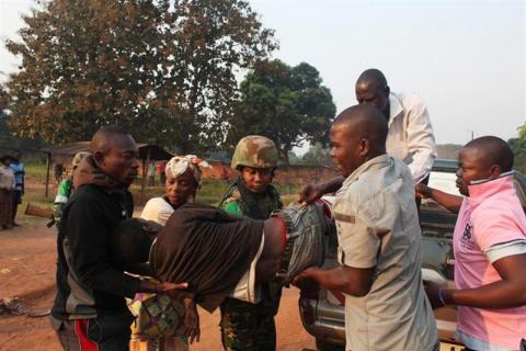 A man wounded in overnight clashes is assisted by peacekeepers and family members in a neighbourhood in Bangui