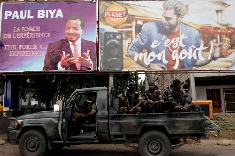 Cameroonian elite Rapid Intervention Battalion (BIR) members sit on their military vehicle under a plazard (L) of Cameroon President Paul Biya, who is running for re-election scheduled for October 7, during a patrol in the south west city of Buea, Cameroon, October 4, 2018. PHOTO BY REUTERS/Zohra Bensemra