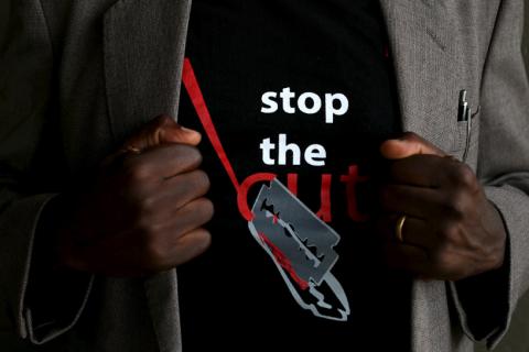 A man shows the logo of a T-shirt that reads "Stop the Cut" referring to Female Genital Mutilation (FGM) during a social event advocating against harmful practices such as FGM at the Imbirikani Girls High School in Imbirikani, Kenya, April 21, 2016. PHOTO BY REUTERS/Siegfried Modola