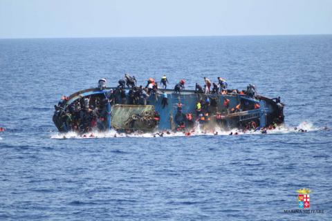 Migrants are seen on a capsizing boat before a rescue operation by Italian navy ships "Bettica" and "Bergamini" off the coast of Libya in this handout picture released by the Italian Marina Militare, May 25, 2016. PHOTO BY REUTERS/Marina Militare