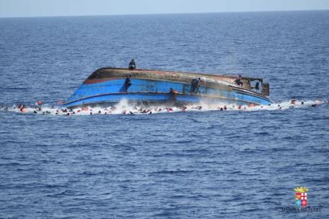 Migrants are seen on a capsizing boat before a rescue operation by Italian navy ships "Bettica" and "Bergamini" off the coast of Libya in this handout picture released by the Italian Marina Militare on May 25, 2016. PHOTO BY REUTERS/Marina Militare