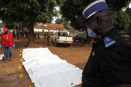 An African peacekeeping soldier stands guard as Red Cross workers move bodies from a mass grave at a military camp in the 200 villas neighbourhood of Bangui in a file picture. PHOTO BY REUTERS/Luc Gnago