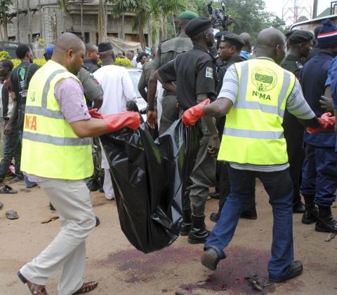 National Emergency Management Agency (NEMA) staff carry a body bag at the scene of a bombing at Alkali Road in Kaduna