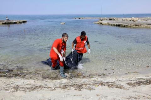 Rescuers carry a bag containing the dead body of a migrant at the coast of Tajoura, east of Tripoli, Libya, June 27, 2017. PHOTO BY REUTERS/Ismail Zitouny