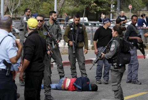 A Palestinian suspected of committing a stabbing attack is surrounded by Israeli border police at the scene of the attack in Jerusalem, October 30, 2015. PHOTO BY REUTERS/Ammar Awad