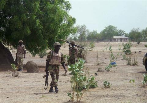 Soldiers walk through Hausari village during a military patrol near Maiduguri, Nigeria, June 5, 2013. According to the military, this camp was one of several belonging to Islamist Boko Haram fighters