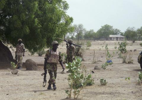 Soldiers walk through Hausari village during a military patrol near Maiduguri, Nigeria