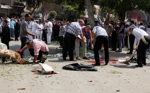 Forensic workers and policemen carry out investigations at the scene of a bomb blast in Cairo