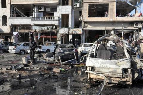 People inspect the site of a double bomb attack in the government-controlled city of Homs, Syria, in this handout picture provided by SANA on January 26, 2016. PHOTO BY REUTERS/SANA