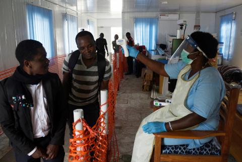 A health worker checks the temperature of a man as he crosses the Mpondwe border point separating Uganda and the Democratic Republic of Congo as part of the ebola screening at the computerised Mpondwe Health Screening Facility in Mpondwe, Uganda, June 13, 2019. PHOTO BY REUTERS/Newton Nabwaya