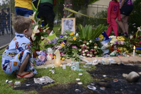 A boy pauses at a shrine outside the home of former South African President Nelson Mandela in Johannesburg